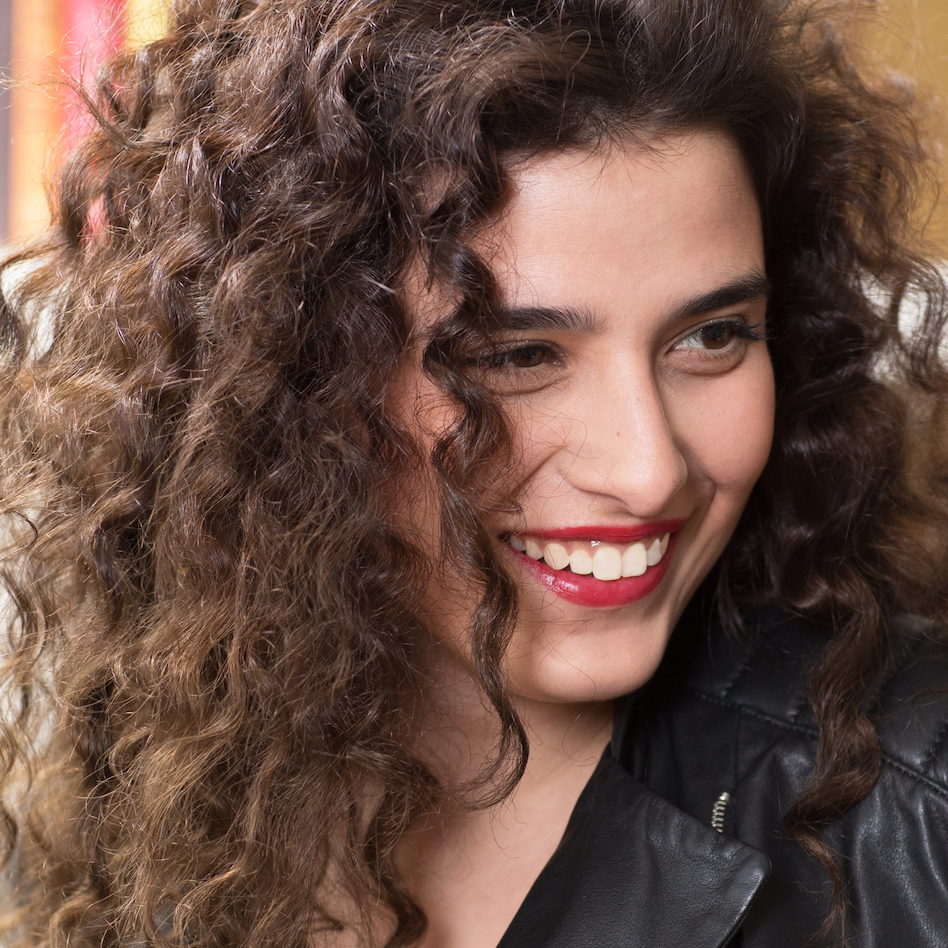 Une femme souriante aux cheveux bouclés parfaitement nourris, illustrant les résultats de la routine Magic Cactus de Shaeri, adaptée aux cheveux secs.